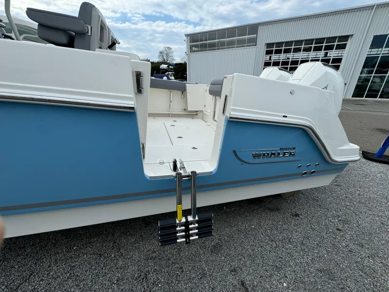 Slide: The Image of 2025 Boston Whaler 280 Outrage boat, blue and white exterior, docked outdoors. - 4