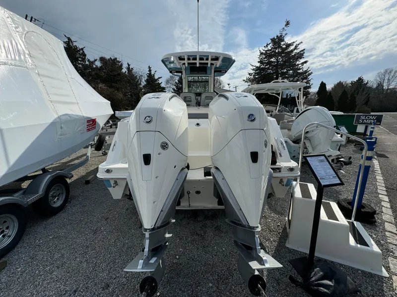 Slide: The Image of 2025 Boston Whaler 280 Outrage with dual outboard engines, displayed outdoors. - 5