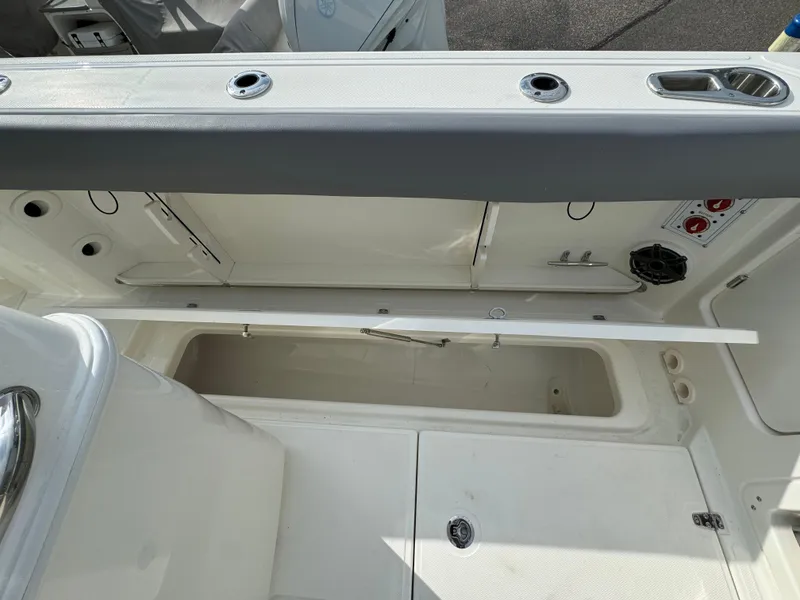 Slide: The Image of 2025 Boston Whaler 280 Outrage interior storage compartment with open hatch and seating. - 8