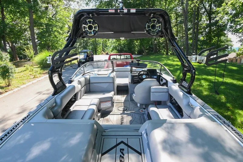 Slide: The Image of 2021 Moomba Kaiyen boat interior with seating and wakeboard tower, parked on a sunny day. - 10