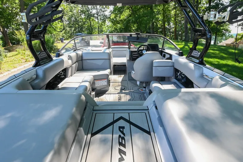 Slide: The Image of 2021 Moomba Kaiyen boat interior with sleek seating and modern dashboard, surrounded by lush greenery. - 14