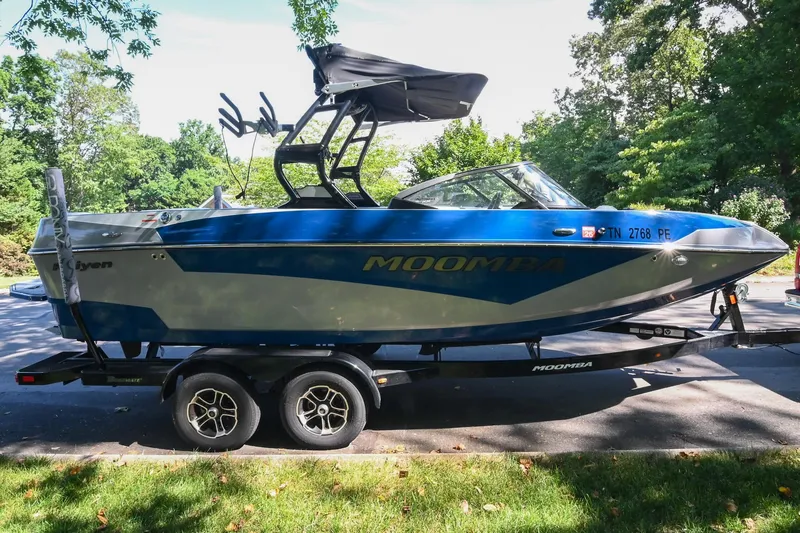 Slide: The Image of 2021 Moomba Kaiyen boat on trailer, parked outdoors with trees in background. - 3