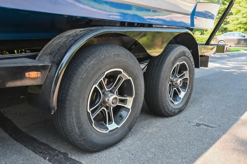 Slide: The Image of Trailer wheels of a 2021 Moomba Kaiyen boat parked on a street. - 40