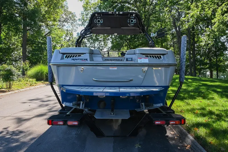 Slide: The Image of 2021 Moomba Kaiyen boat rear view, parked on a tree-lined road. - 5