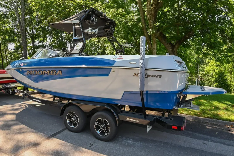 Slide: The Image of 2021 Moomba Kaiyen boat on trailer, parked on a tree-lined street. - 6