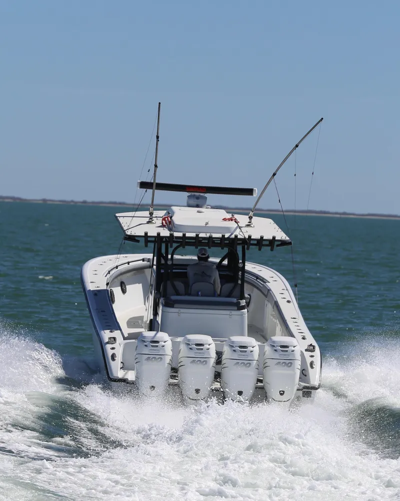Slide: The Image of 2018 Yellowfin 39 boat speeding on open water with multiple outboard engines. - 16