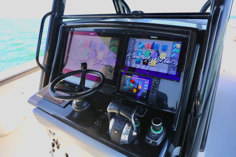 Slide: The Image of 2018 Yellowfin 39 boat dashboard with dual Simrad displays and steering wheel. - 19