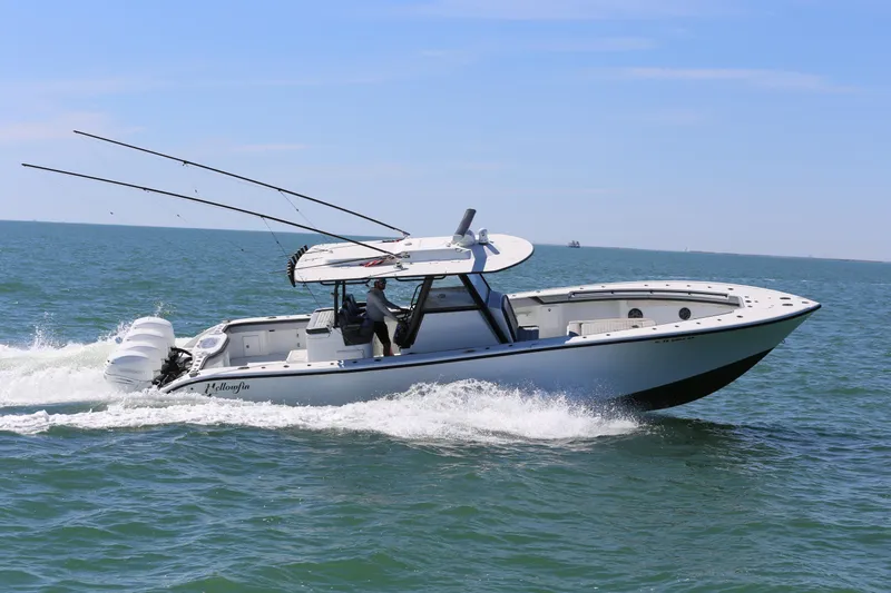 Slide: The Image of 2018 Yellowfin 39 boat cruising on open water, equipped with fishing rods and triple engines. - 4