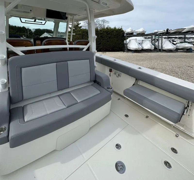 Slide: The Image of 2025 Boston Whaler 380 Outrage interior with gray seating and spacious deck. - 11