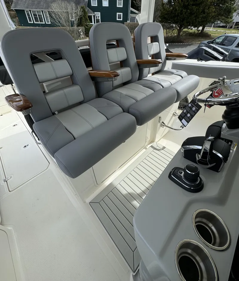 Slide: The Image of 2025 Boston Whaler 380 Outrage helm with three gray seats and control panel. - 13