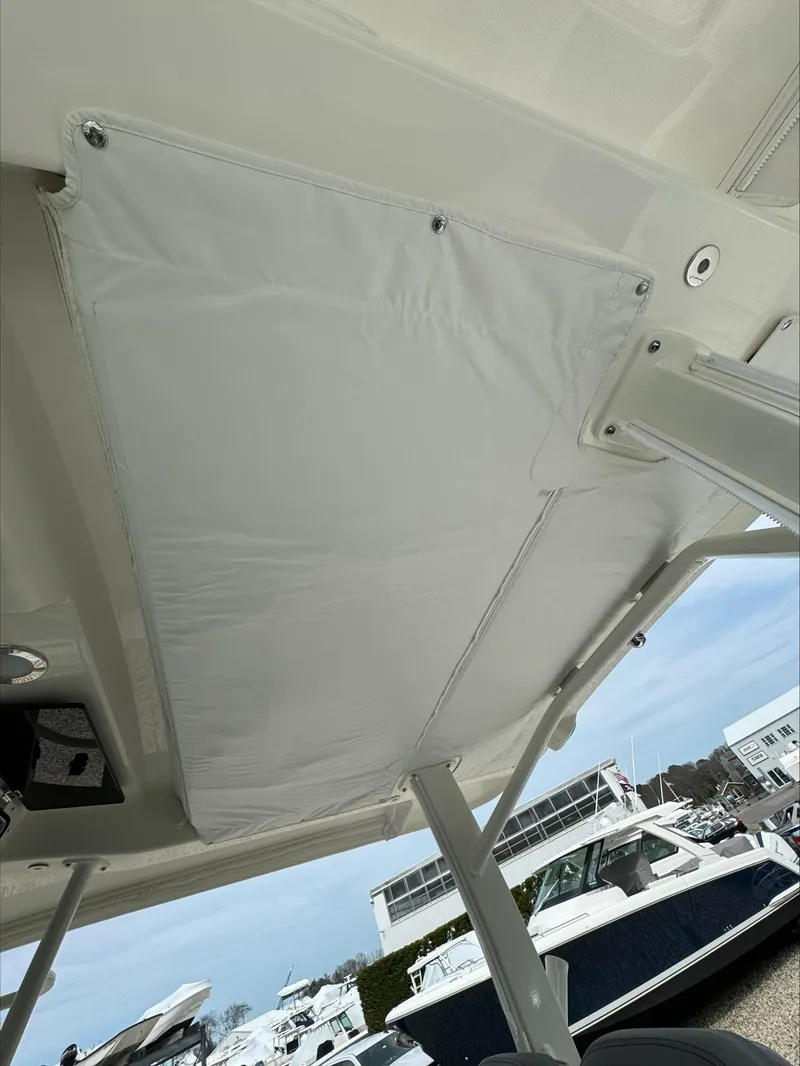 Slide: The Image of Boston Whaler 380 Outrage 2025 boat canopy detail with marina background. - 15