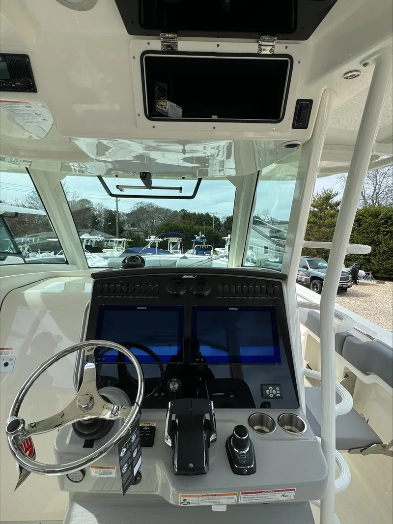 Slide: The Image of 2025 Boston Whaler 380 Outrage helm with dual screens and steering wheel. - 19