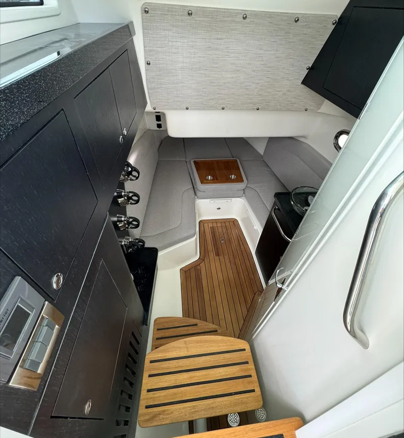 Slide: The Image of 2025 Boston Whaler 380 Outrage cabin interior with modern amenities and wooden accents. - 21