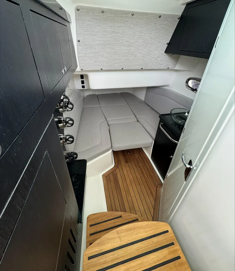 Slide: The Image of 2025 Boston Whaler 380 Outrage cabin interior with wood flooring and cushioned seating. - 23