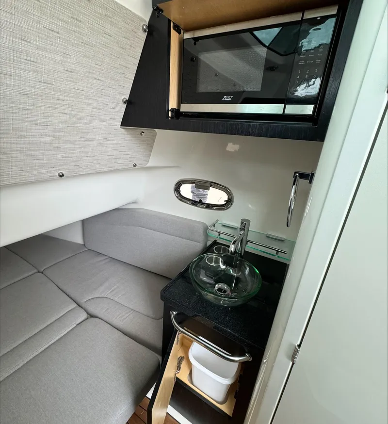 Slide: The Image of Interior of 2025 Boston Whaler 380 Outrage with sofa, sink, and microwave. - 26