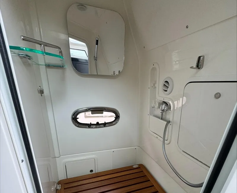 Slide: The Image of Interior of 2025 Boston Whaler 380 Outrage boat, featuring a compact, modern bathroom. - 27
