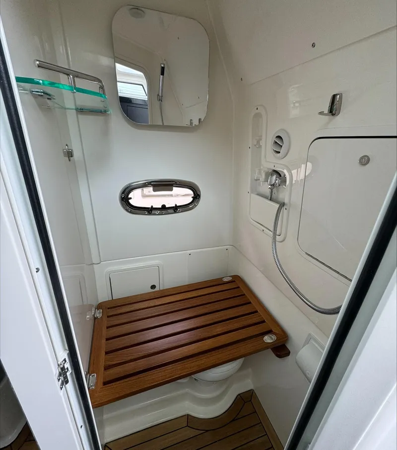 Slide: The Image of 2025 Boston Whaler 380 Outrage bathroom with wooden seat and modern fixtures. - 29