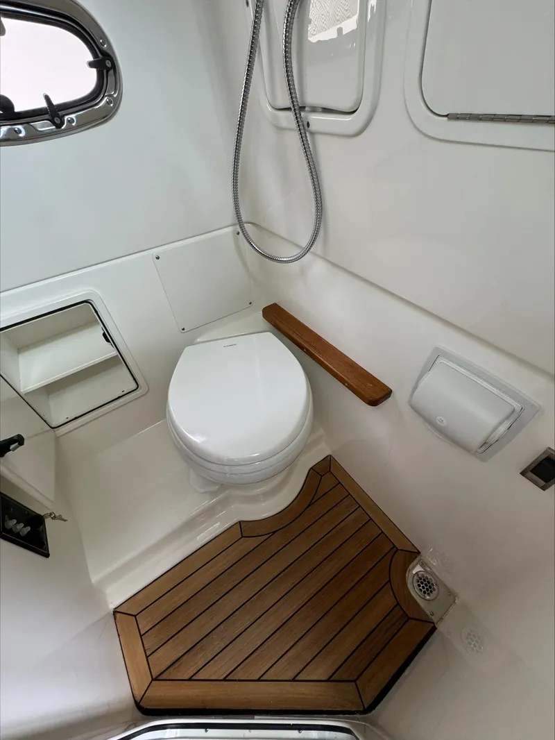 Slide: The Image of 2025 Boston Whaler 380 Outrage bathroom with toilet, shower, and wooden floor. - 30