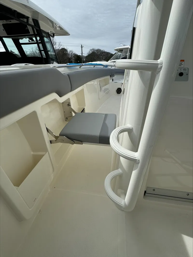 Slide: The Image of 2025 Boston Whaler 380 Outrage interior with foldable seat and storage compartments. - 33