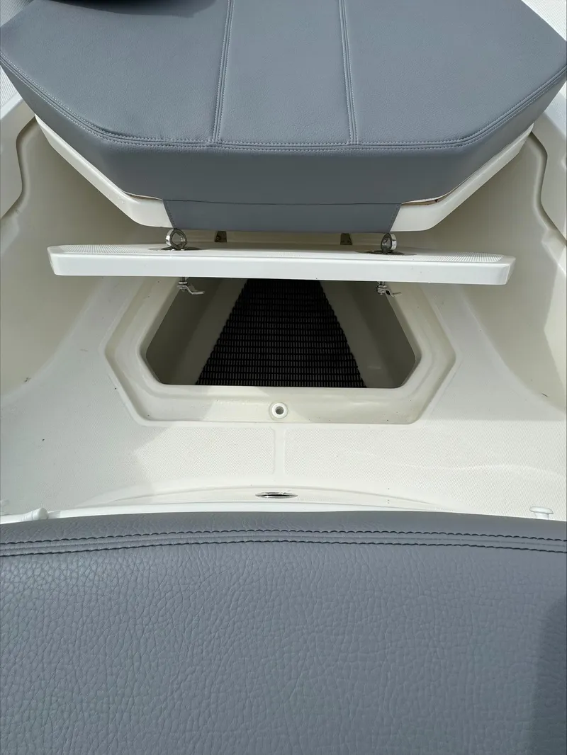 Slide: The Image of 2025 Boston Whaler 380 Outrage storage compartment with gray cushioned seating. - 39