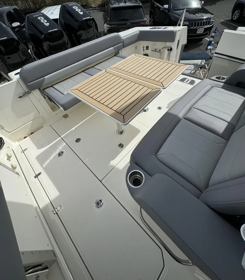 Slide: The Image of 2025 Boston Whaler 380 Outrage boat interior with seating and wooden table. - 5