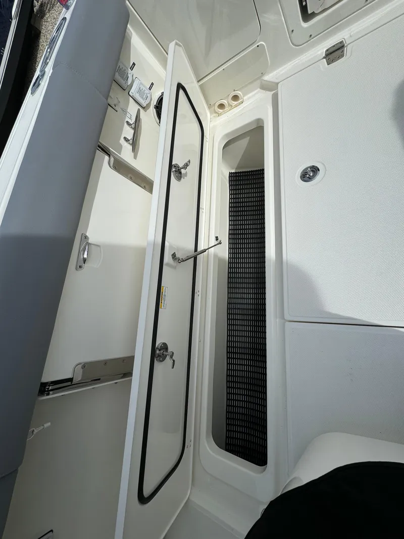 Slide: The Image of 2025 Boston Whaler 380 Outrage interior storage compartment with open door and sleek design. - 6