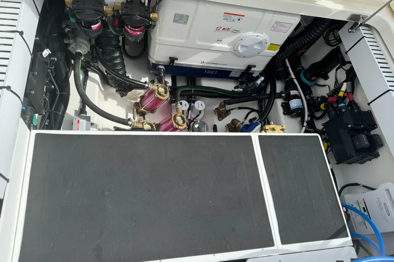 Slide: The Image of Engine compartment of a 2025 Boston Whaler 380 Outrage, showcasing mechanical components and wiring. - 9