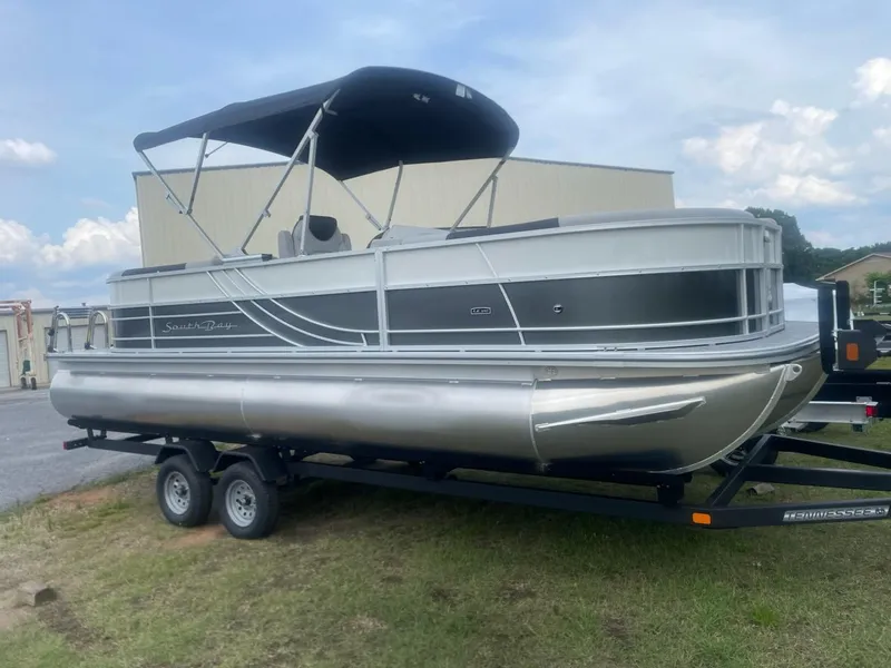 The Image of 2025 South Bay 224RS LE 2.75 pontoon boat on trailer, parked outdoors. - 0