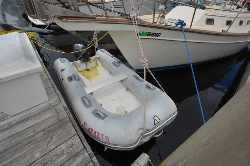 Slide: The Image of Inflatable dinghy moored beside a 1994 Island Packet 44 sailboat at a dock. - 10