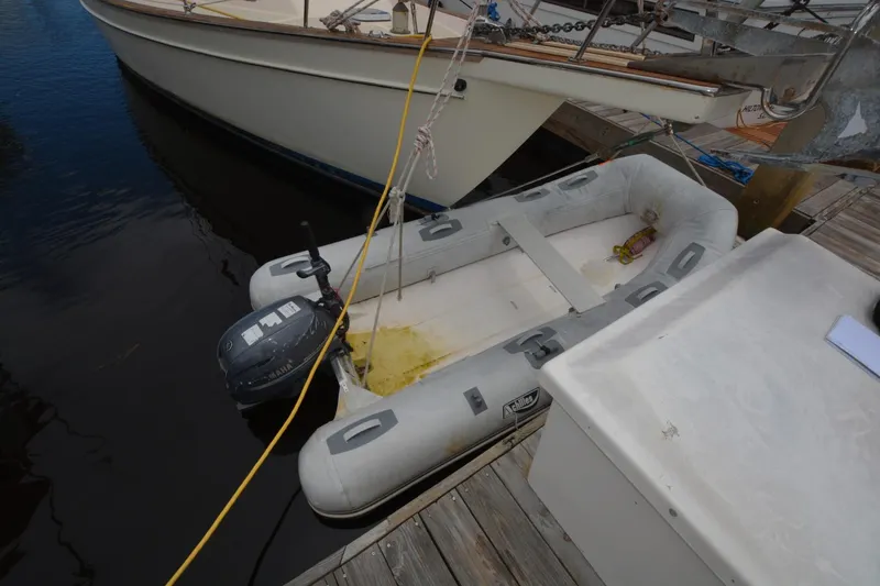 Slide: The Image of Inflatable dinghy with outboard motor docked beside Island Packet 44 sailboat, 1994 model. - 11