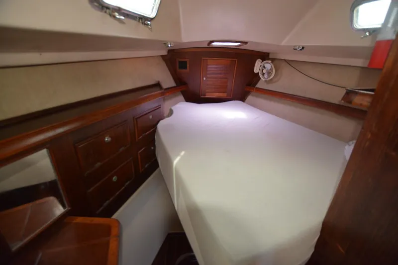 Slide: The Image of Cozy cabin interior of 1994 Island Packet 44 sailboat with bed and wooden storage. - 12