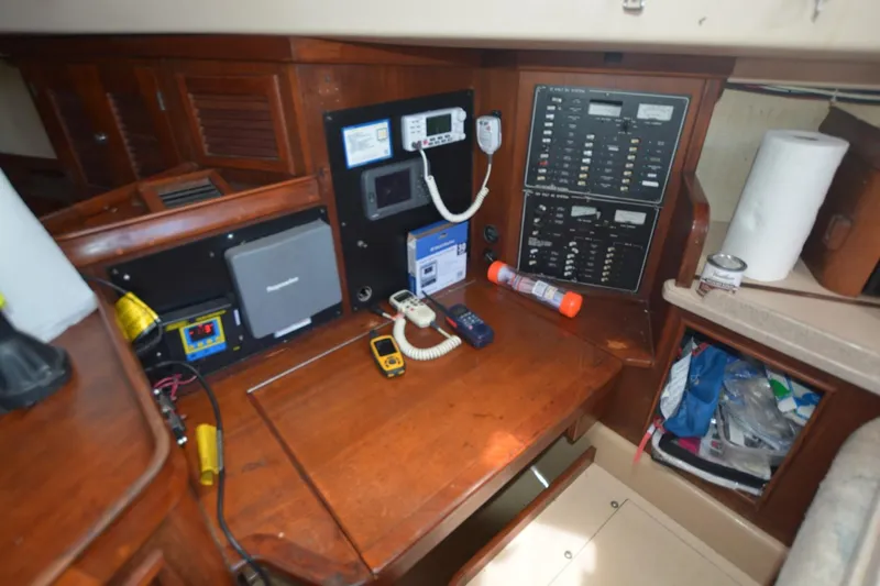 Slide: The Image of Navigation station of a 1994 Island Packet 44 sailboat with control panels and equipment. - 18