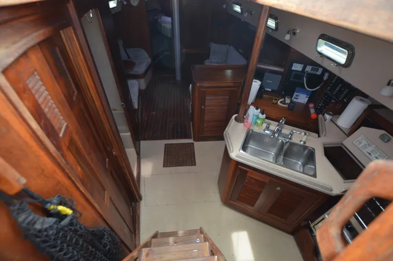 Slide: The Image of Interior of 1994 Island Packet 44 sailboat with wooden cabinetry and kitchen area. - 20