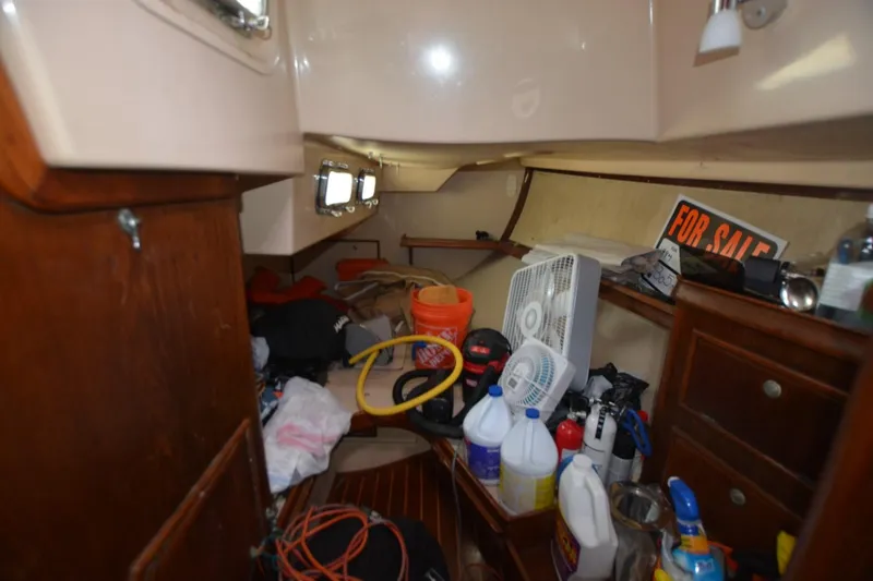 Slide: The Image of Interior of a 1994 Island Packet 44 sailboat with clutter and a "For Sale" sign. - 21