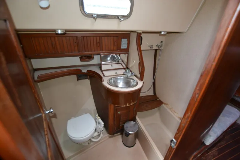 Slide: The Image of 1994 Island Packet 44 yacht bathroom with sink, toilet, and shower. - 22