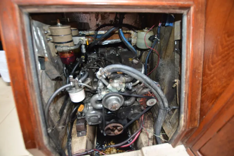 Slide: The Image of Engine compartment of a 1994 Island Packet 44 sailboat, showing mechanical components and wiring. - 23