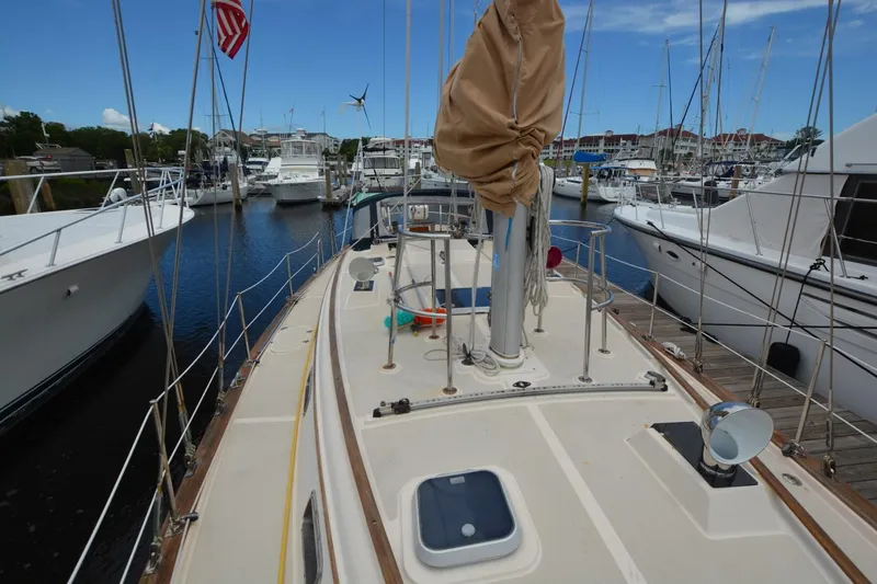 Slide: The Image of 1994 Island Packet 44 sailboat docked in a marina, surrounded by other boats. - 4
