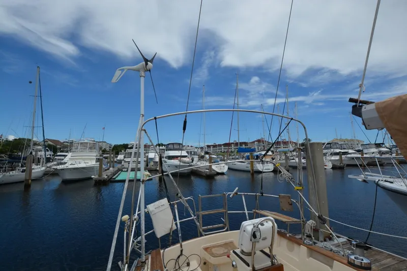 Slide: The Image of Sailboat docked in marina, Island Packet 44, 1994, with wind turbine and clear sky. - 8