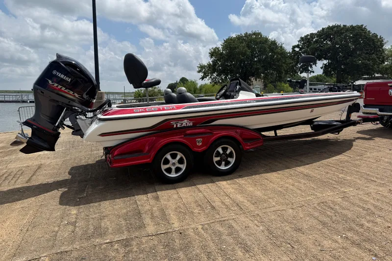 Slide: The Image of 2011 Skeeter FX 21 boat with Yamaha engine on a trailer, parked outdoors. - 14
