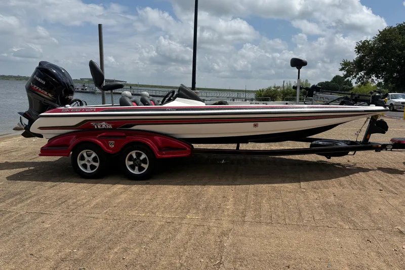 Slide: The Image of 2011 Skeeter FX 21 boat on trailer by a lake under cloudy sky. - 16