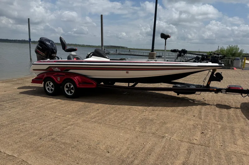 Slide: The Image of 2011 Skeeter FX 21 boat on trailer by a lake under cloudy sky. - 17