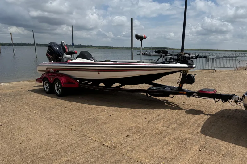 Slide: The Image of 2011 Skeeter FX 21 boat on trailer by a lake under cloudy sky. - 18