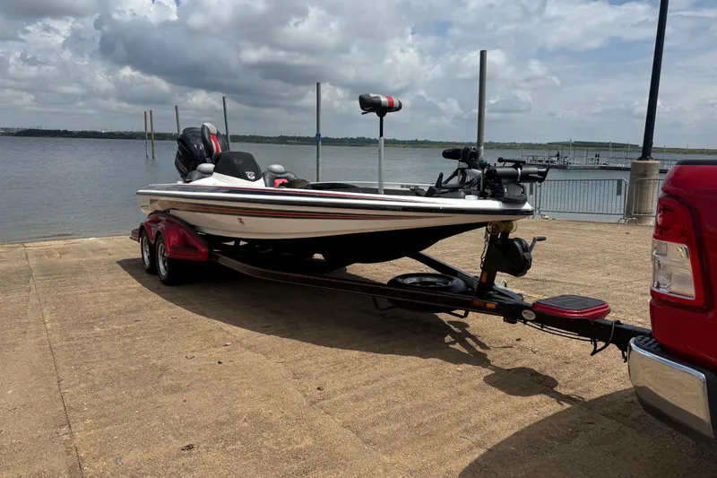 Slide: The Image of 2011 Skeeter FX 21 boat on trailer by a lake under cloudy sky. - 19