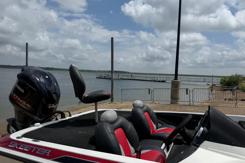 Slide: The Image of 2011 Skeeter FX 21 boat with Yamaha engine by a lake under cloudy skies. - 22