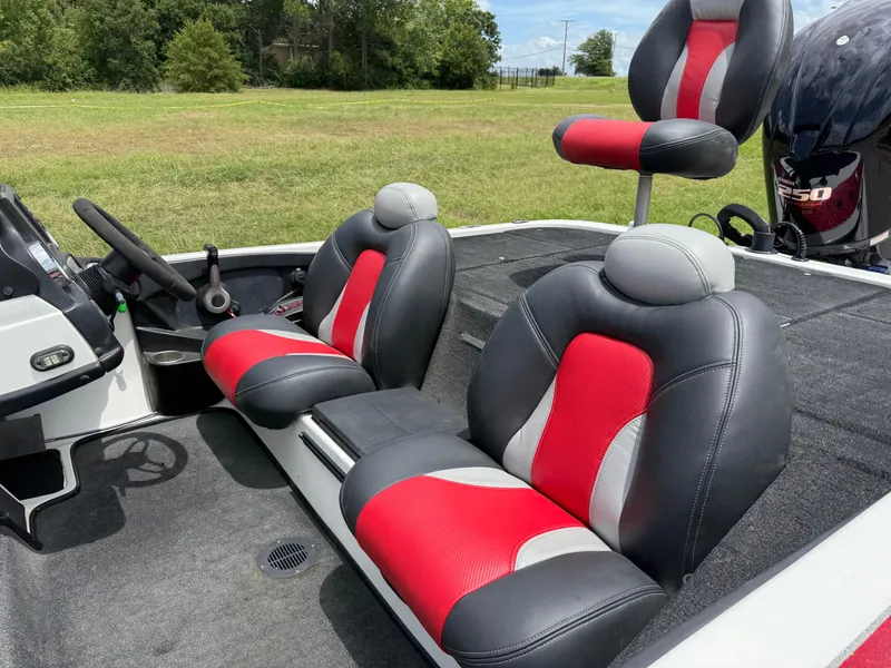 Slide: The Image of 2011 Skeeter FX 21 boat interior with red and gray seats, steering wheel, and motor. - 27