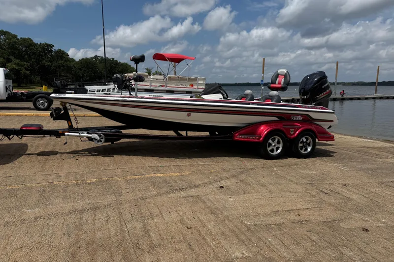 Slide: The Image of 2011 Skeeter FX 21 boat on trailer by a lake under a cloudy sky. - 3