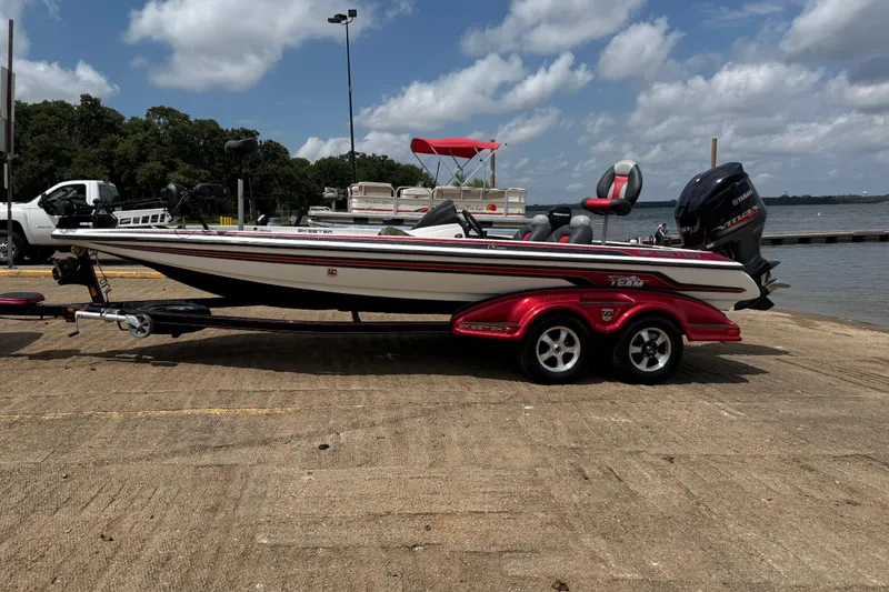 Slide: The Image of 2011 Skeeter FX 21 boat on trailer by a lake under a cloudy sky. - 4