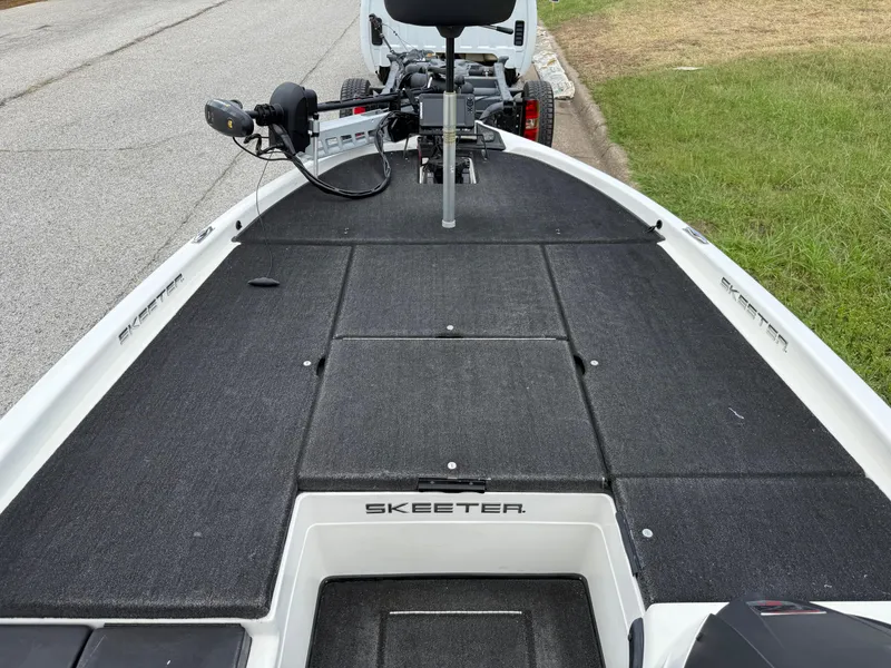 Slide: The Image of 2011 Skeeter FX 21 boat deck with trolling motor, parked on roadside. - 48
