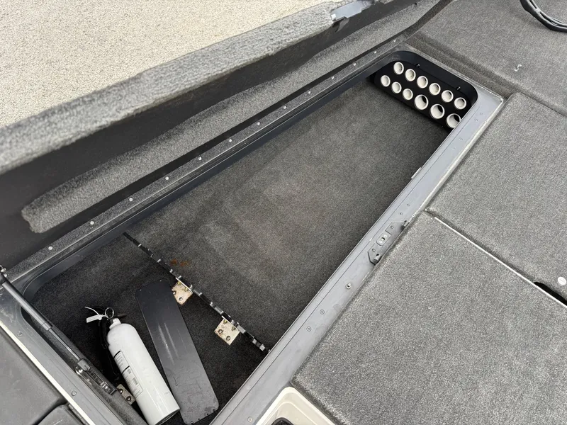 Slide: The Image of 2011 Skeeter FX 21 boat storage compartment with rod holders and fire extinguisher. - 49