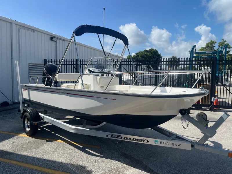 Slide: The Image of 2022 Boston Whaler 170 Montauk boat on trailer, parked outdoors under blue sky. - 4